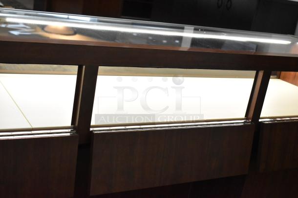 Wooden lighted jewelry case with two rear doors, in good condition, featuring a transparent top display area.