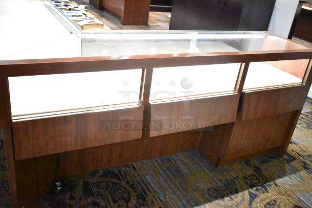 Wooden lighted jewelry case with glass top, two rear doors, and solid wood finish. Buyer removal required, bring tools.