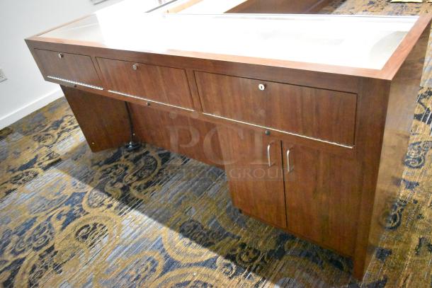 Wooden lighted jewelry case with glass display top, two rear doors, secure locks. Requires tools for removal.