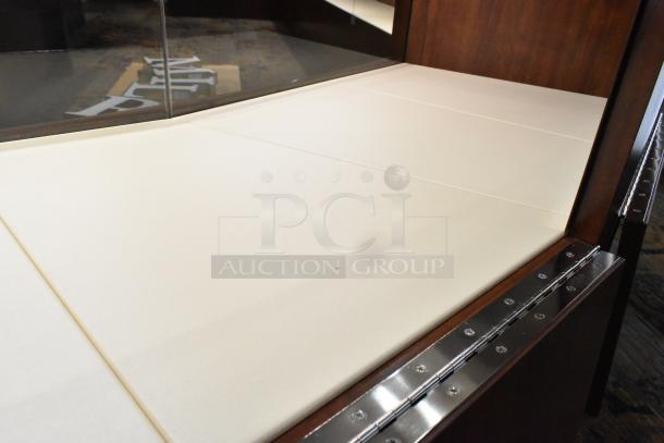 Wooden lighted jewelry case with four rear doors, glass top, and metal accents. Requires tools for removal.