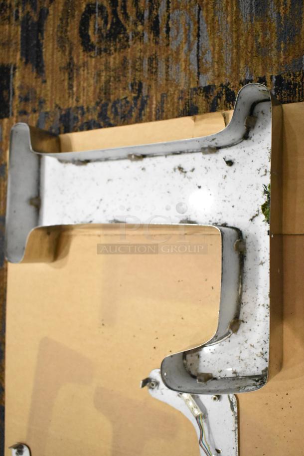 White L-shaped letter with a silver finish frame showing wear and minor surface dirt, suitable for display or signage.