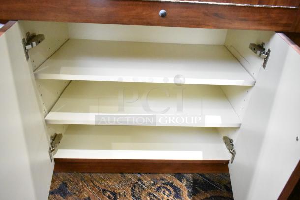 Lighted wooden jewelry display case with two rear sliding doors, open shelving, and interior lighting. Buyer removal required.