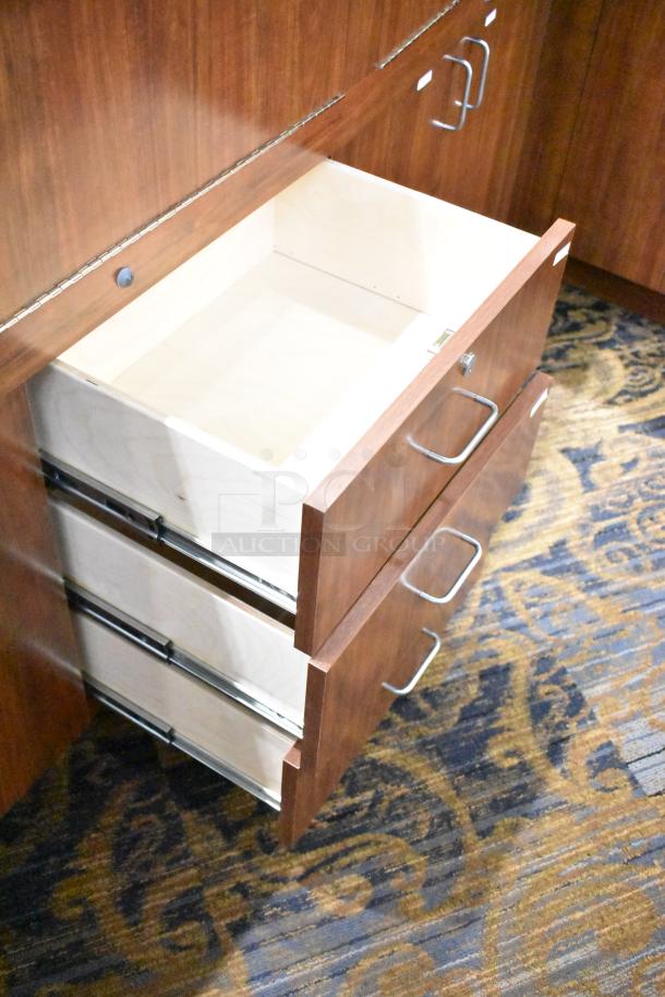 Lighted wooden jewelry display case with two rear sliding doors and metal handles, shown with open storage drawers.