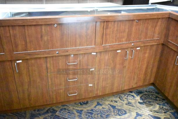 Lighted wooden jewelry display case with rear sliding doors and drawers, good condition. Buyer must remove; tools needed.