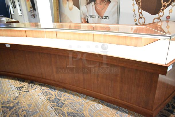 Lighted wooden jewelry display case with glass top, 6 rear doors, and 3 drawers. Buyer must remove; tools and manpower needed.