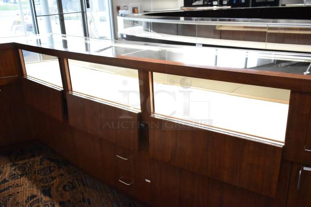 Lighted wooden jewelry display case with glass top, 6 rear doors, and 3 drawers. Excellent for showcasing items. Buyer must remove.