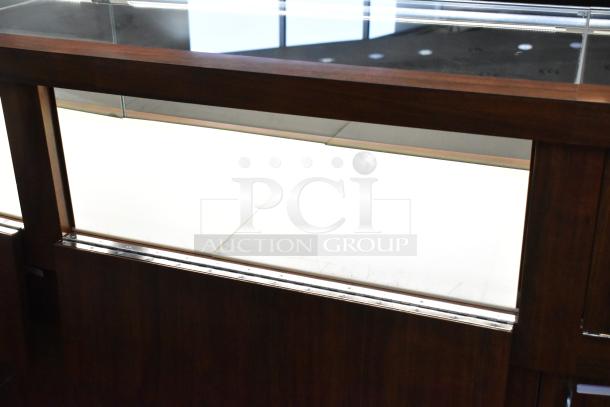 Lighted wooden jewelry display case with glass top, 6 rear doors, 3 rear drawers, in good condition. Buyer removes.