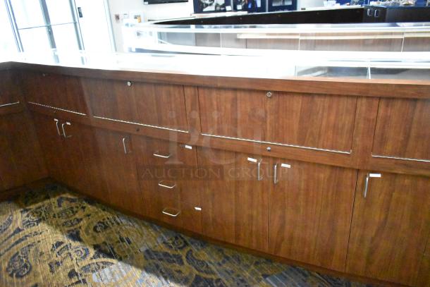 Lighted wooden jewelry display case with 6 rear doors, 3 drawers. Wooden finish. Includes lighting. Buyer must remove.