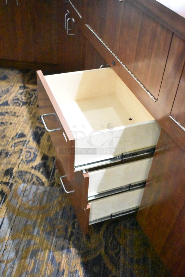 Lighted wooden jewelry display case with six rear doors and three rear drawers; one drawer partially open.