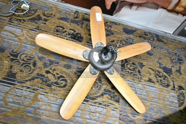 48-ATR ceiling mount fan with 5 wooden blades, 120 volts, 1 phase. Central wiring visible. Auction tag attached.