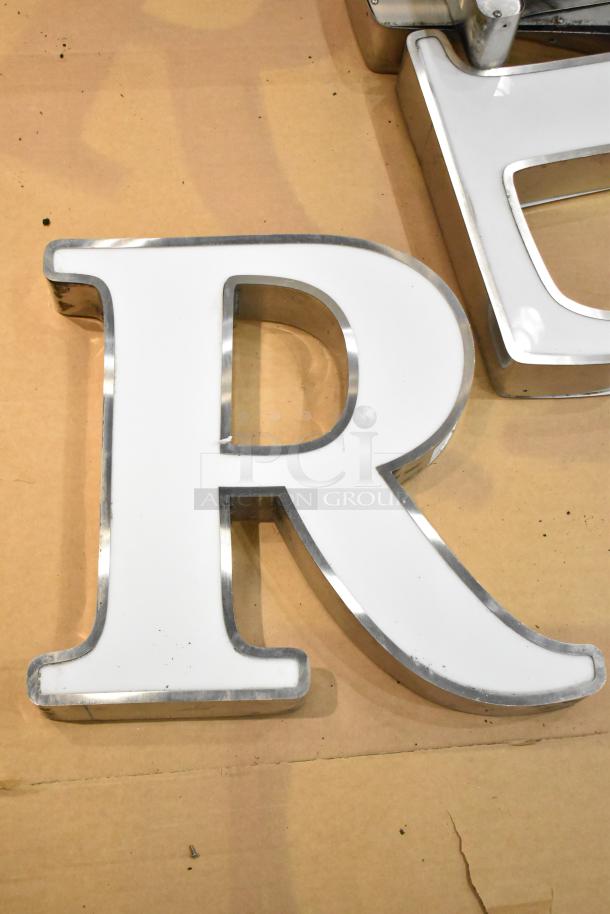 White letter "R" with silver finish frame, good condition, ideal for signage or decor.