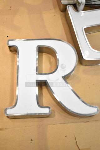 White letter "R" with silver finish frame, good condition, ideal for signage or decor.
