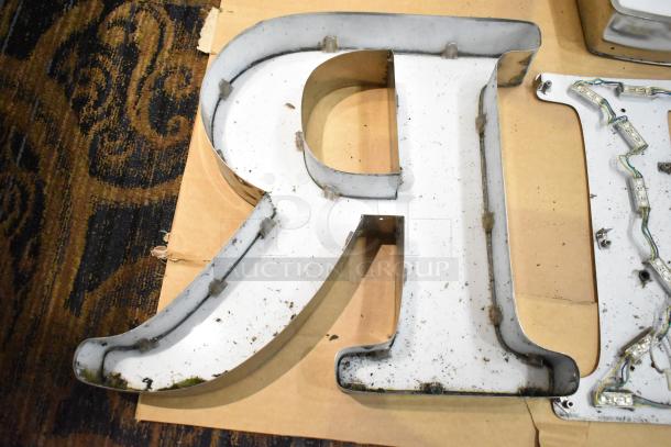 White letter "R" with silver finish frame, used condition, minor dirt marks, suggests prior outdoor signage use.