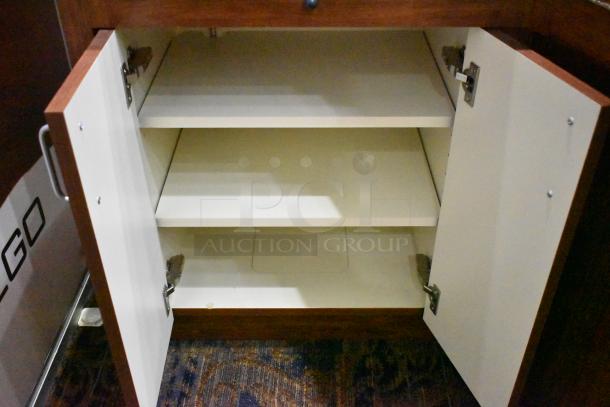 Lighted wooden jewelry display case with two rear doors, open shelving, and visible wear; requires buyer removal.