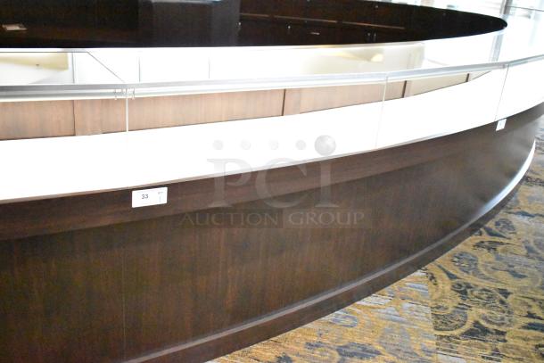 Curved wooden jewelry display case with lighting, rear doors, and drawers. Bring tools for removal. Item tag 33 visible.