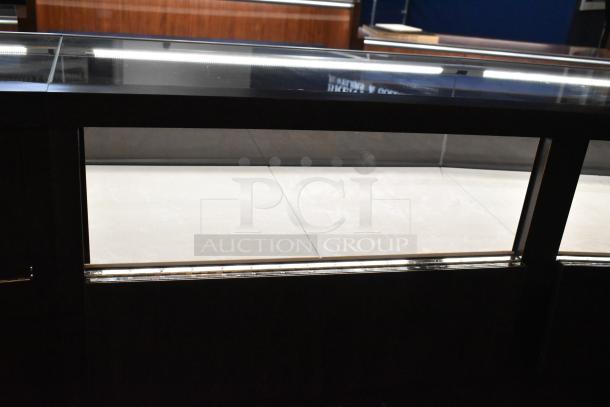 Lighted curved wooden jewelry display case with glass front, rear doors, drawers, and a light strip. Buyer must remove.