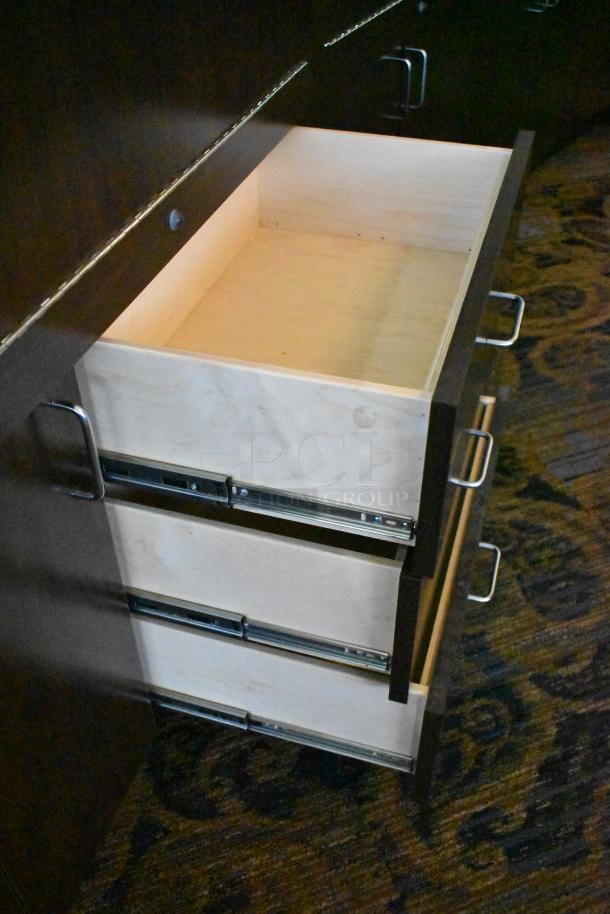 Lighted curved wooden jewelry display case with rear doors and drawers, in good condition, prominent metal handles.