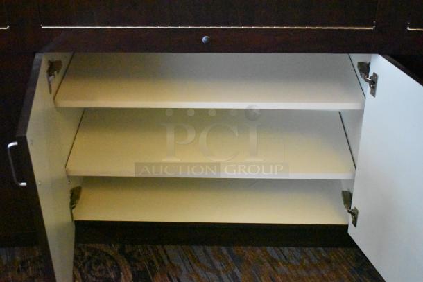 Lighted curved wooden jewelry display case with four rear doors open, showing internal shelving. Tools and manpower needed for removal.