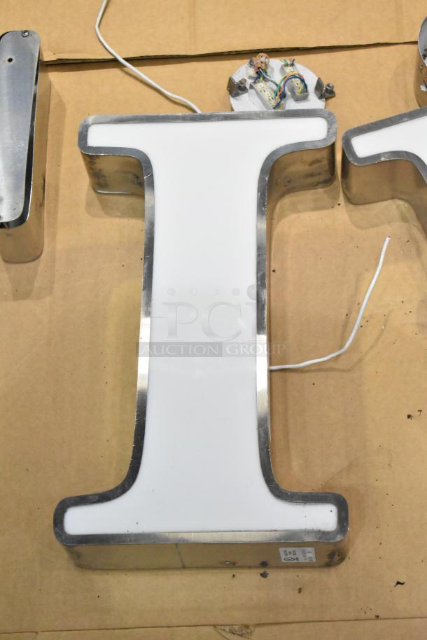 White "I" letter with silver finish frame, featuring wiring for electrical connection; clean, good condition.
