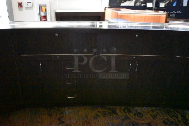 Wooden lighted jewelry case with three rear doors and three drawers. Buyers must remove. Bring tools and manpower.