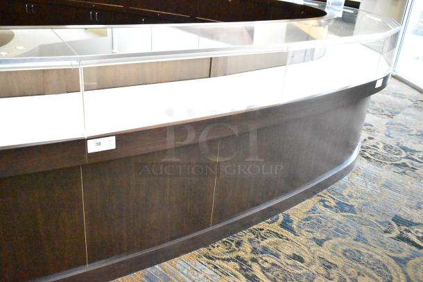 Wooden lighted jewelry case, curved glass top, three rear doors, three drawers, good condition. Removal requires tools.