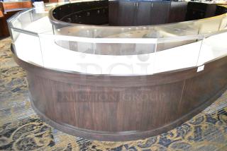 Wooden curved lighted jewelry case with glass front, four rear doors, dark wood finish, in good condition.