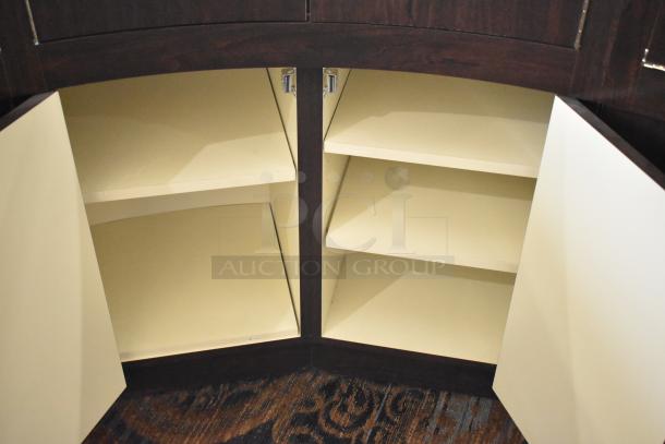 Wooden curved lighted jewelry case with four rear doors, beige interior shelves, good condition. Buyer must remove.