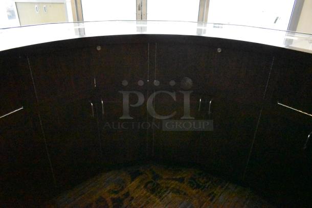 Curved wooden jewelry case with glass top and integrated lighting, featuring four rear doors. Buyer must remove.