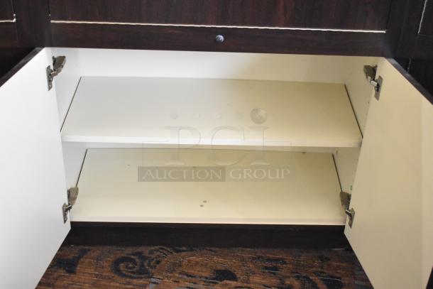 Wooden lighted jewelry case with three rear doors, three drawers shown open. Note: Buyer must bring tools to remove.