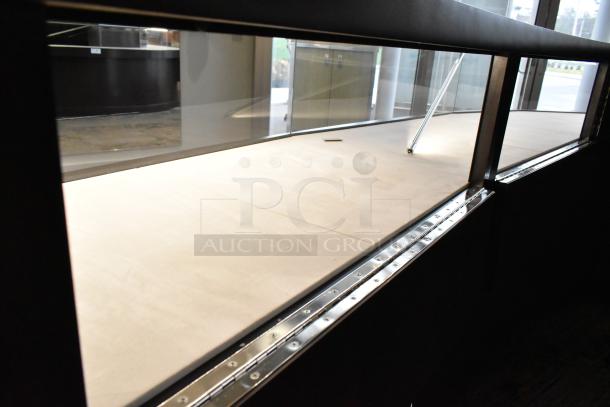 Wooden lighted jewelry case with three rear doors and three drawers. Requires tools and manpower for removal.