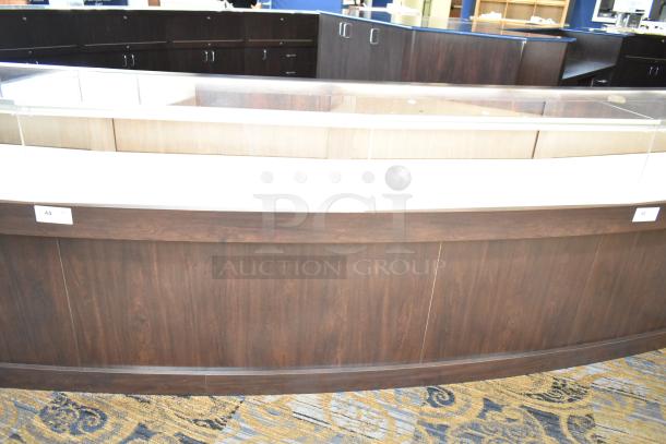 Wooden lighted jewelry case with four rear doors and glass display, dark wood finish, requires removal by buyer.
