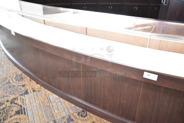 Wooden lighted jewelry case with four rear doors, glass display top, in good condition. Buyer must bring tools for removal.