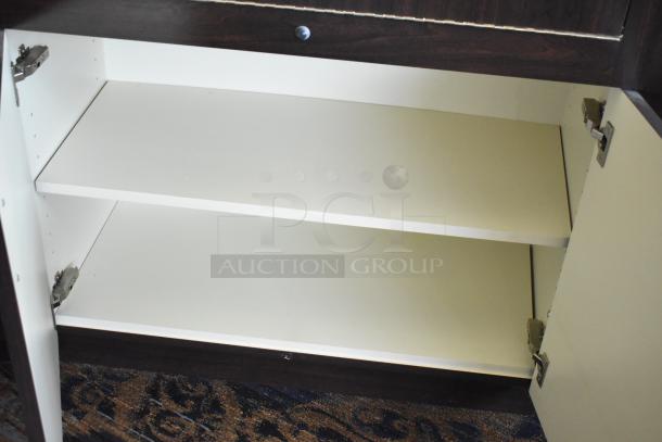 Wooden lighted jewelry case with four rear doors, spacious interior, hinges visible; requires tools for removal.