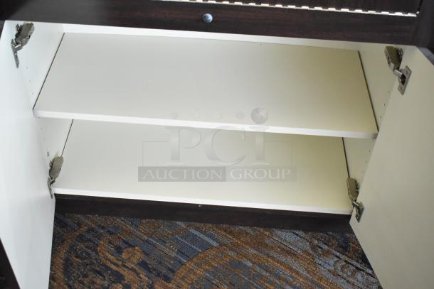 Wooden lighted jewelry case with open double front doors, cream interior shelves, and dark wood exterior. Bring tools to remove.