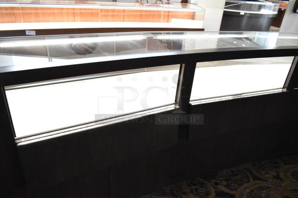 Wooden lighted jewelry case with four rear doors, in good condition. Removal requires buyer tools and manpower.