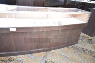 Wooden lighted jewelry case with glass top, 3 rear doors, and 3 drawers. Dark wood finish. Some assembly required for removal.