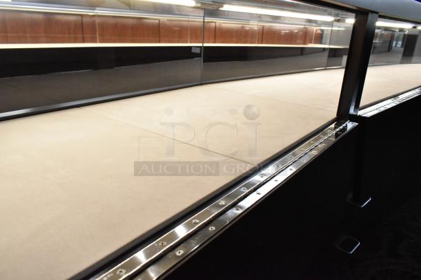 Wooden lighted jewelry case with three rear doors and three drawers. Good condition. Buyer must remove. Bring tools.