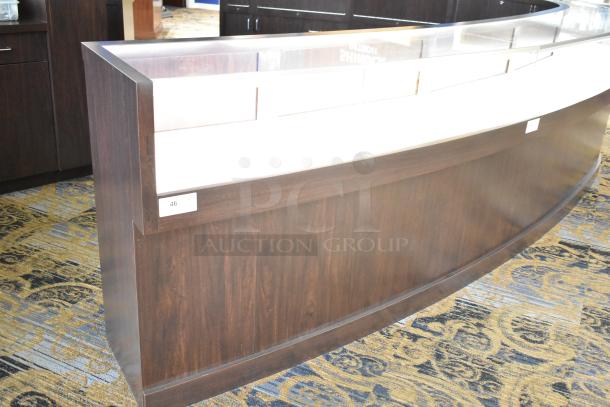 Wooden lighted jewelry case with four rear doors, dark wood finish, curved design. Buyer must remove; bring tools.