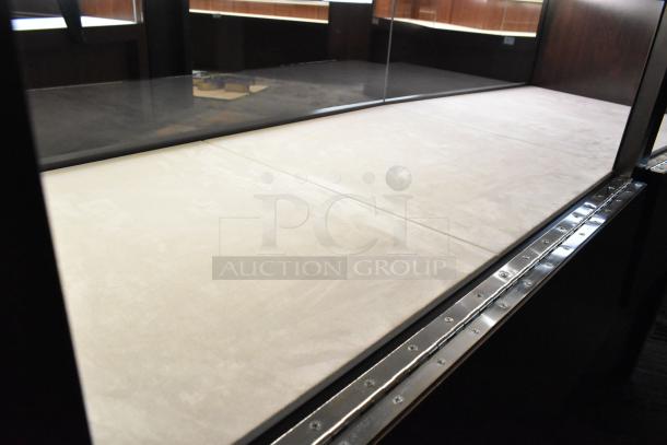 Wooden lighted jewelry case with four rear doors, clean surface, metal edge detailing, spacious interior; buyer must remove.