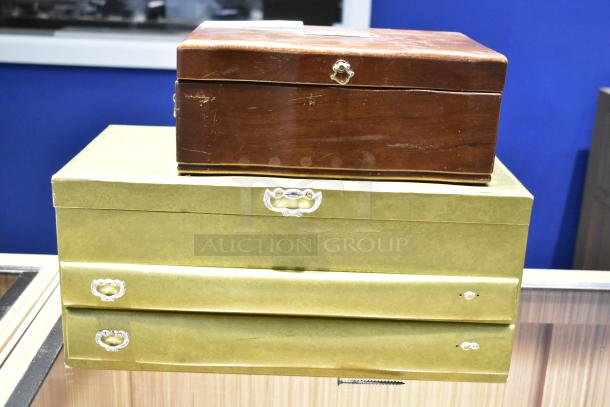 Two jewelry cases; one wooden and one gold-toned, containing a watch, pin, and necklaces. Visible wear on wooden case.
