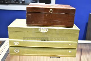 Two jewelry cases; one wooden and one gold-toned, containing a watch, pin, and necklaces. Visible wear on wooden case.