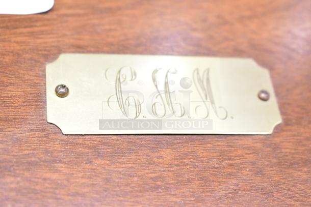 Two wooden jewelry cases with a brass plaque engraved "C.H.M." Each includes assorted jewelry: watch, pin, necklaces.