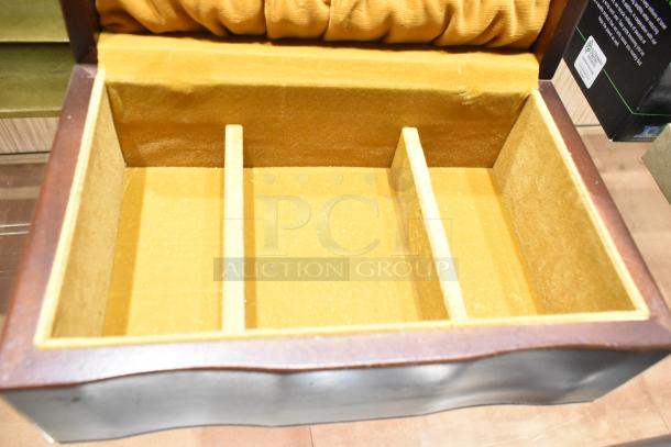 Open wooden jewelry case with yellow velvet lining and three compartments. Part of auction lot with watch, pin, necklaces.