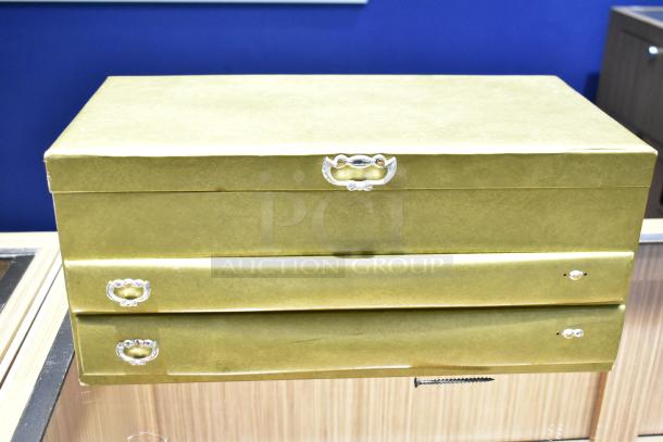 Gold jewelry cases with two drawers, featuring polished handles. Contains a watch, pin, and necklaces. Auction item.
