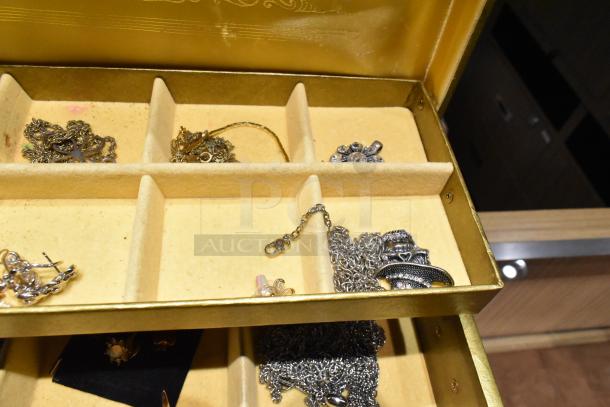 Two jewelry cases with mixed contents, including a watch, pin, and necklaces, in good condition.