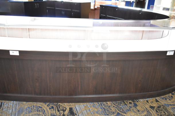 Wooden lighted jewelry case with 3 rear doors, 3 drawers; dark wood finish, good condition. Buyer must bring tools to remove.