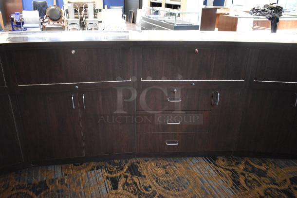 Wooden lighted jewelry case with 3 rear doors and 3 drawers. Buyer must bring tools and manpower for removal.