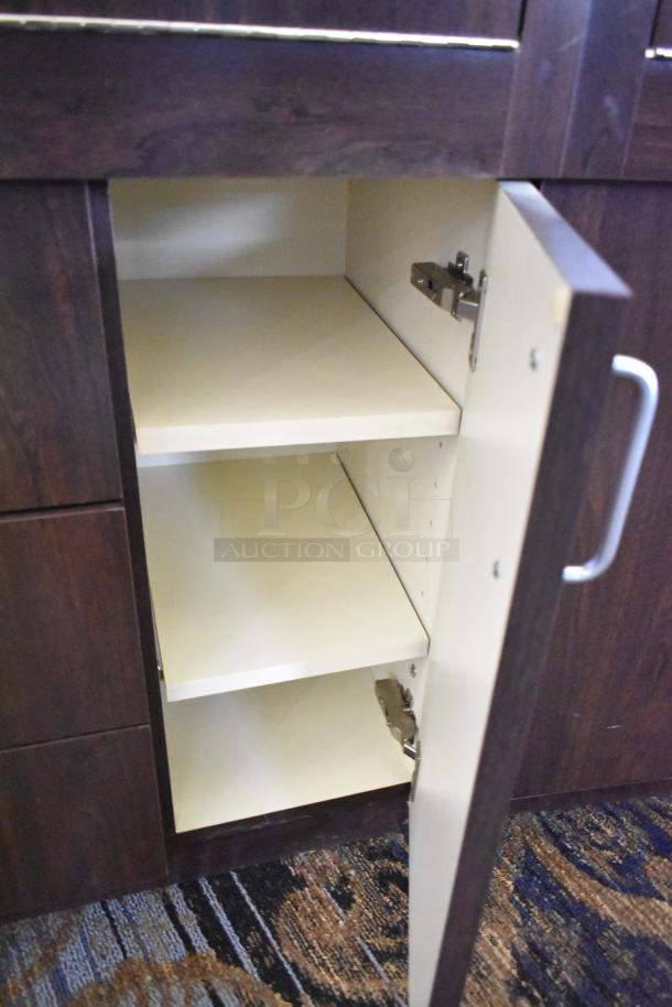 Wooden lighted jewelry case with 3 rear doors, 3 drawers. Dark wood finish, needs tools and manpower for removal.