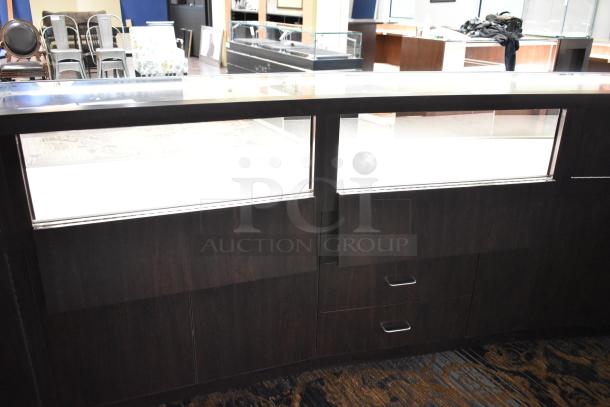 Wooden lighted jewelry case with three rear doors, three drawers, and glass display top. Buyer must remove.