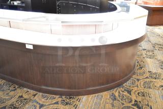 Curved wooden jewelry case with lighting, four rear doors, glass display top. Buyer to remove; bring tools and manpower.